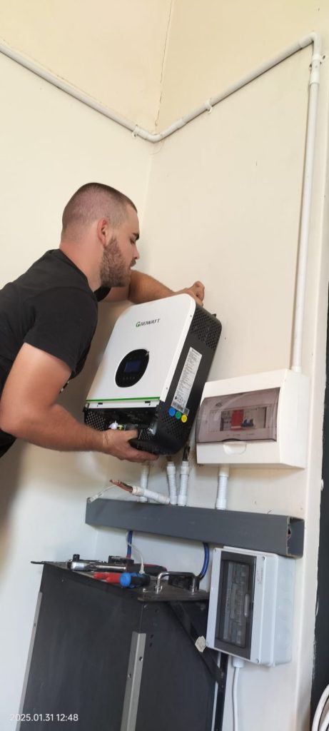 Technician wiring solar inverter for home energy system