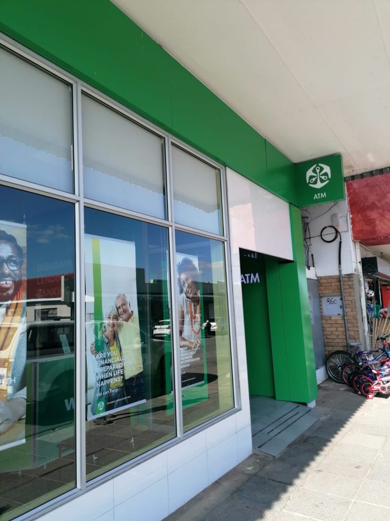 Electrician fixing exterior signage lighting at Old Mutual building in Parys